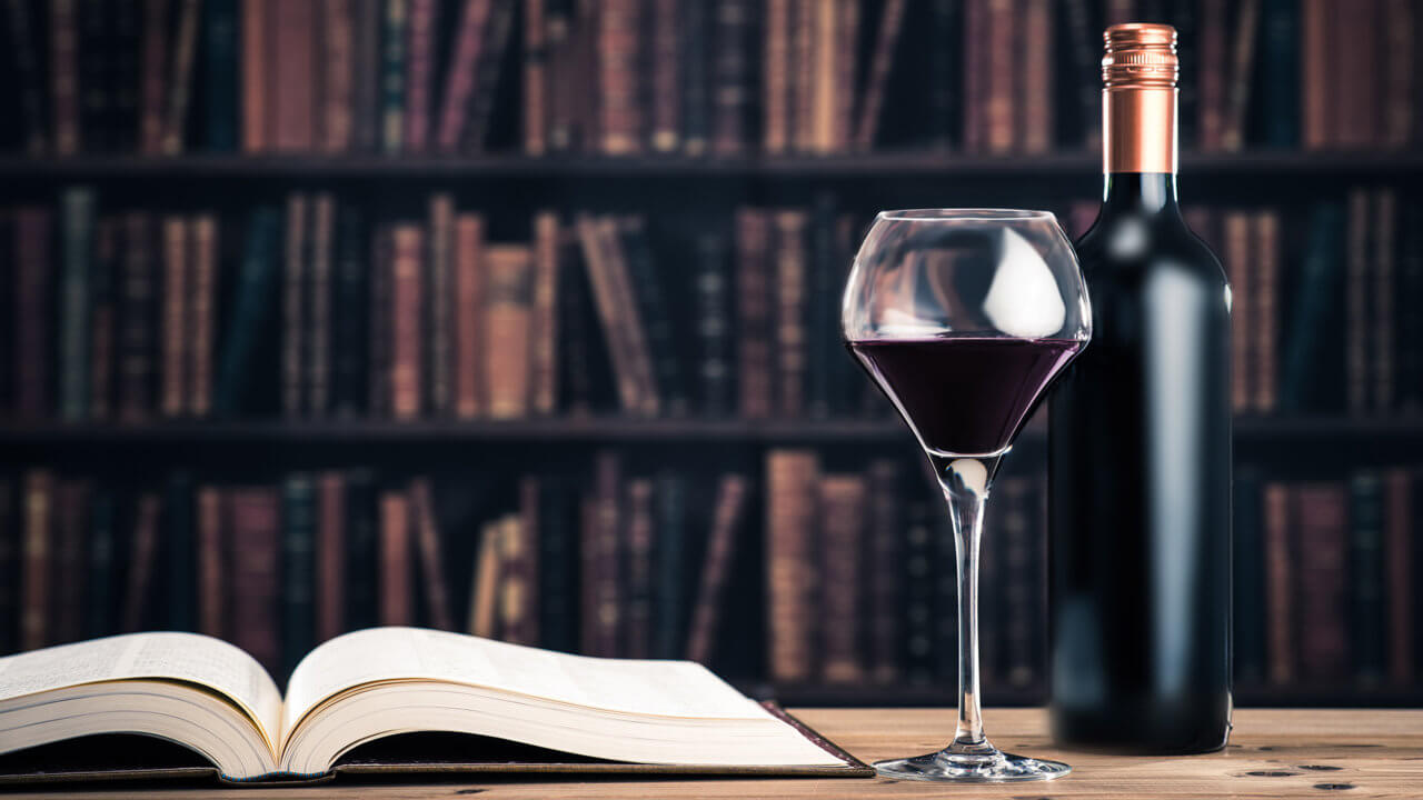 Wein auf dem Tisch mit Buch in der Bibliothek
